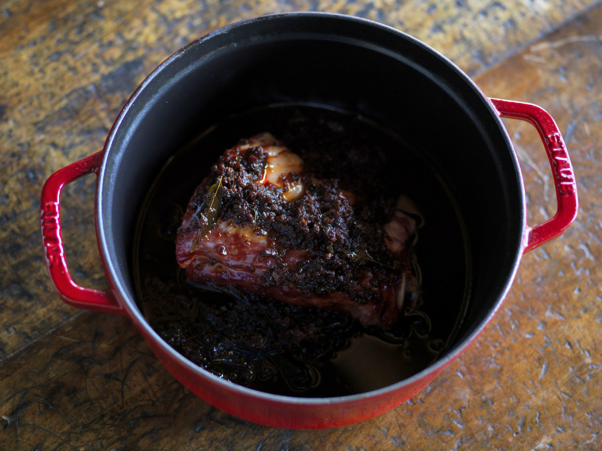 Lamb neck is braised in a cast iron pot with smoked tomato sambal.