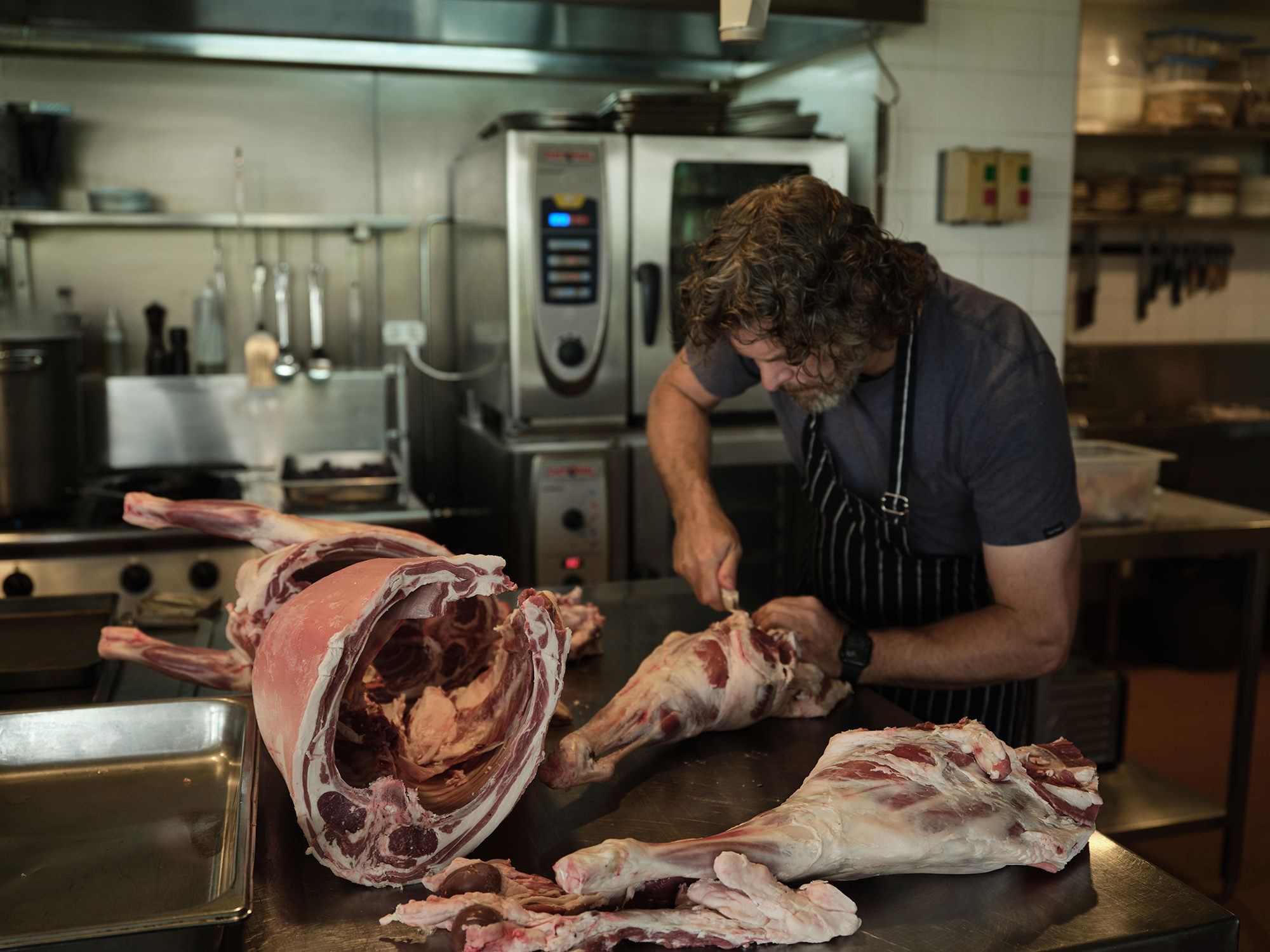 Trevor breaking down a lamb carcase at the restaurant.