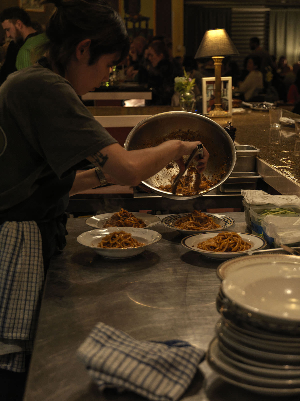 Plating up the Bouillabaisse Bolognese – Shanghai noodles with lamb ragu, prawn/ bacon XO, smoked koji, cucumber and shallots.