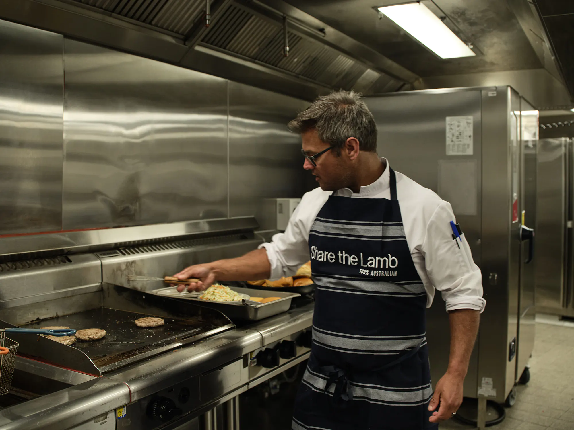 MCG chef Luke Bowden prepares lamb burgers for The Lamb Paddock 